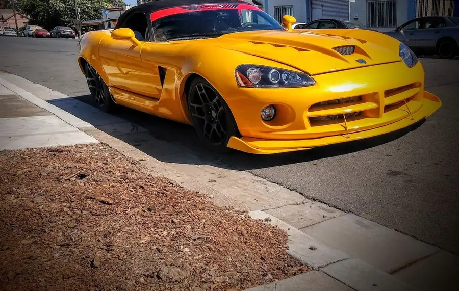 Finished yellow Dodge Viper with fresh paint parked at the curb